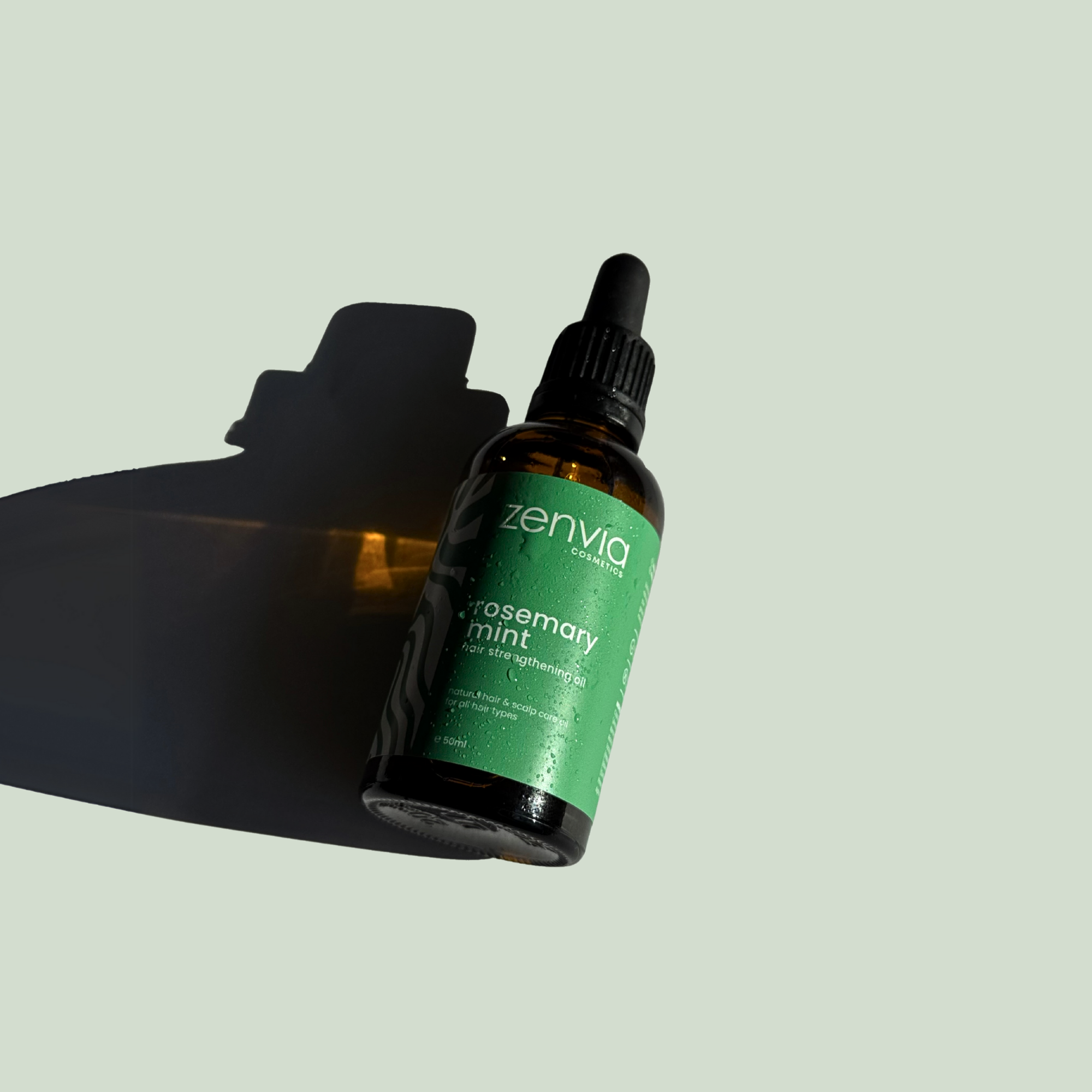 Bottle of Zenvia rosemary mint hair oil on a light background